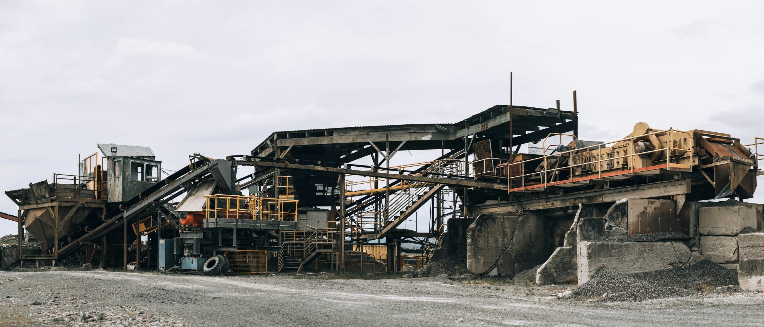 A stone crushing and screening plant with conveyors and stockpiles at a materials yard.