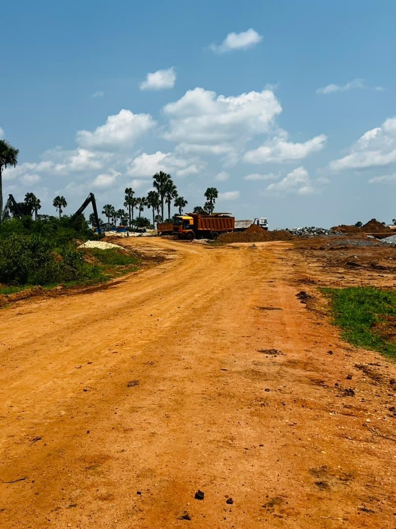 A wide gravel road corridor running through cleared bushland under an open sky.